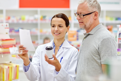 happy pharmacist and a senior customer with drug and prescription at a drugstore